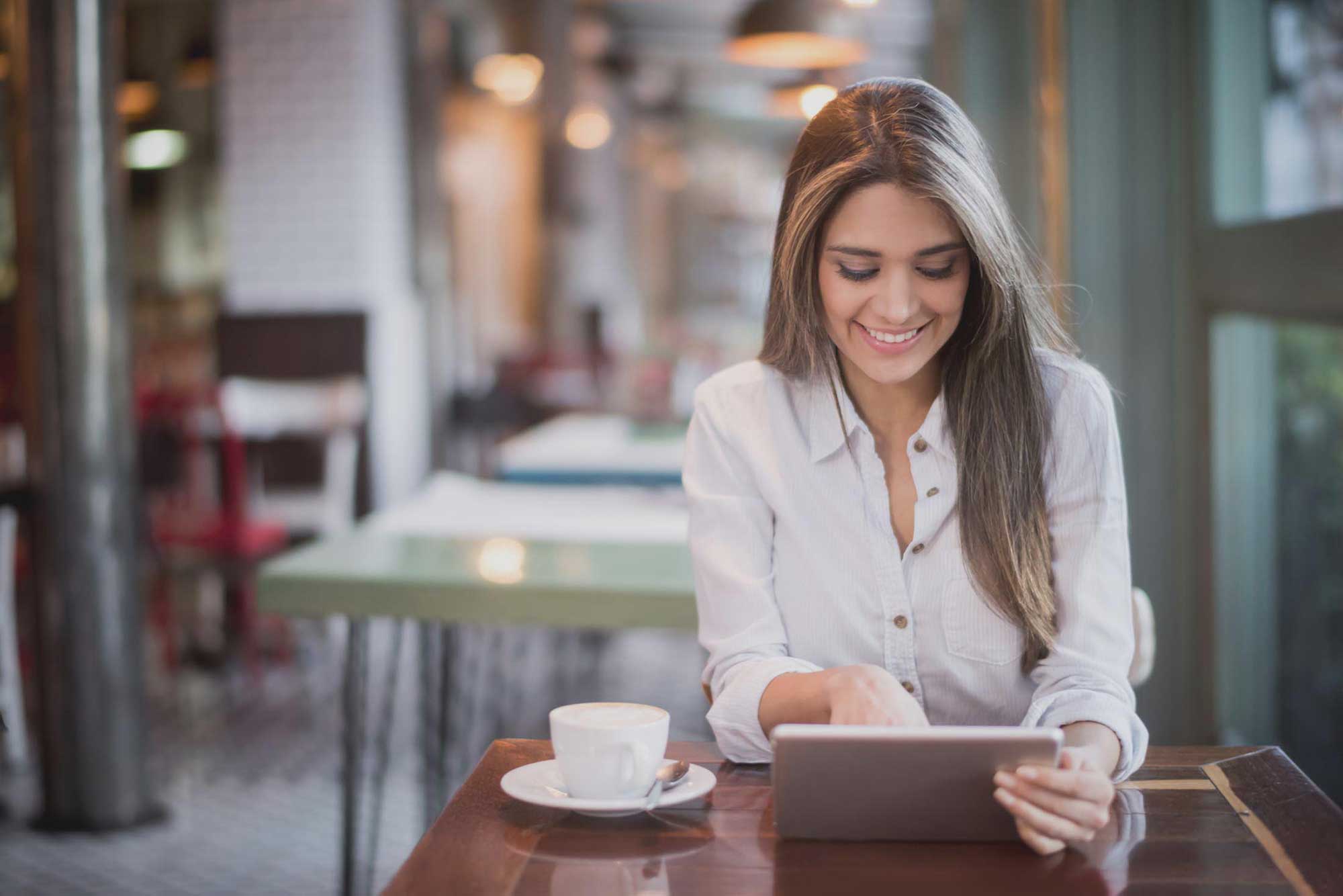 Woman in a cafe looking at her tablet